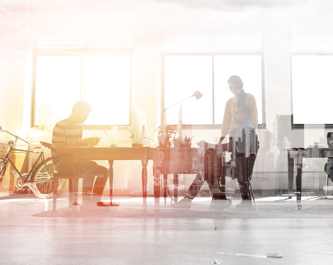 Multiple exposure shot of colleagues working in a modern office superimposed over a city background
